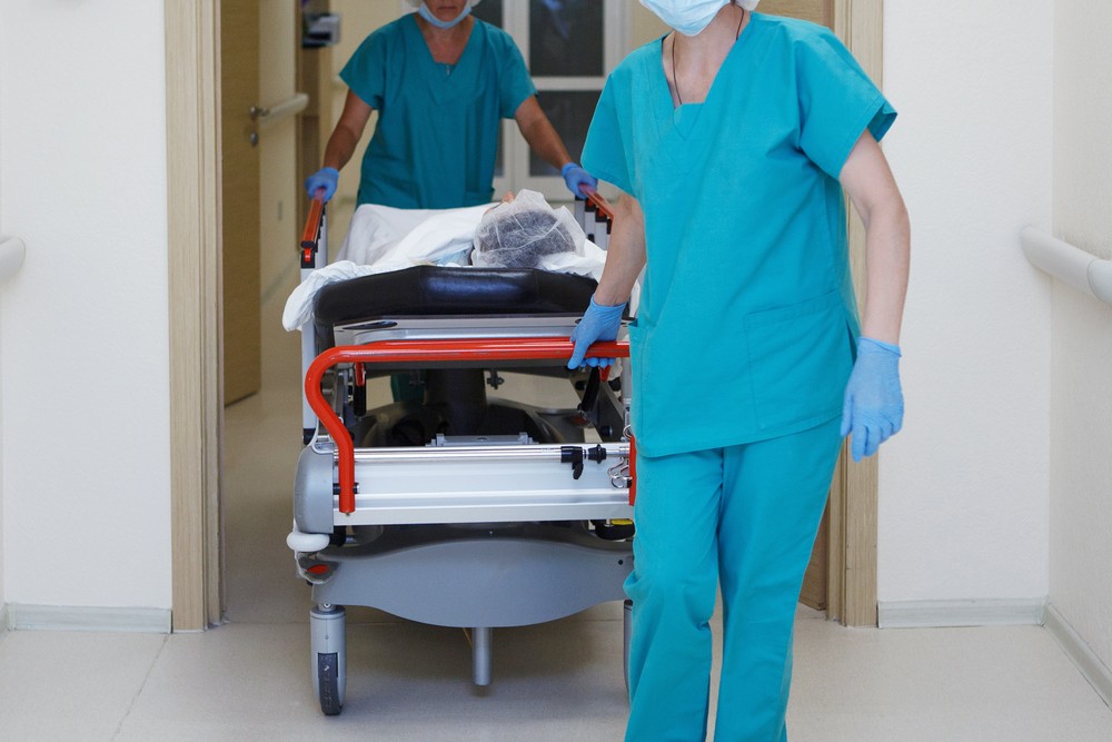 Des infirmiers poussant un lit d'hôpital.