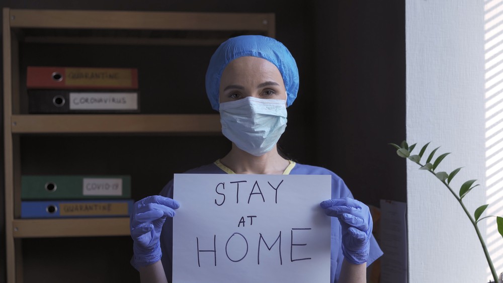 Une infirmière demandant aux gens de rester chez eux.