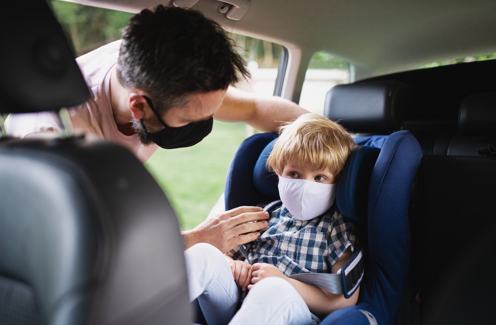 Un père de famille portant un masque obligatoire, avec son enfant.