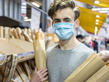 Des consommateurs portant un masque contre le Covid-19 dans un supermarché.