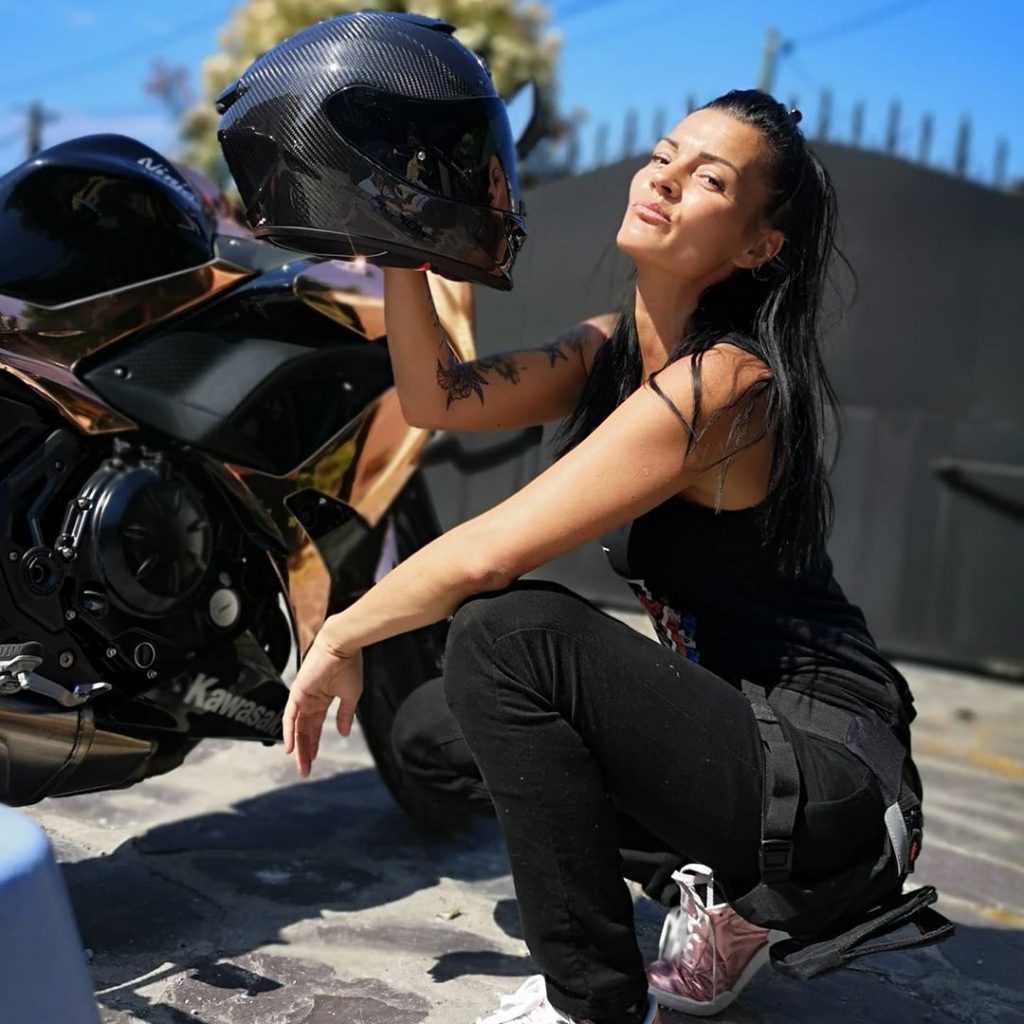 Jessica Potel pose avec ses casques de moto.