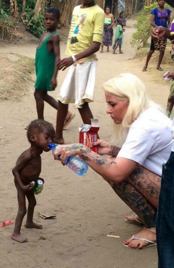 Hope, enfant abandonné au Nigeria car sorcier, avec Anja qui lui donne à boire.