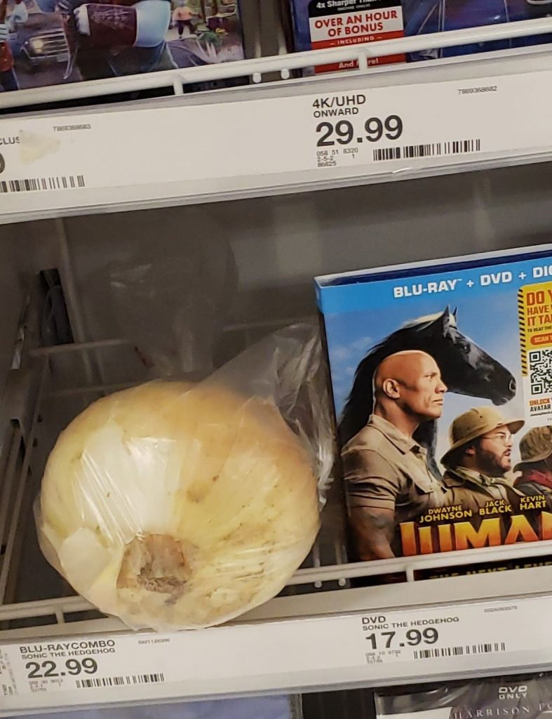 un oignon rangé au rayon DVD d'un supermarché