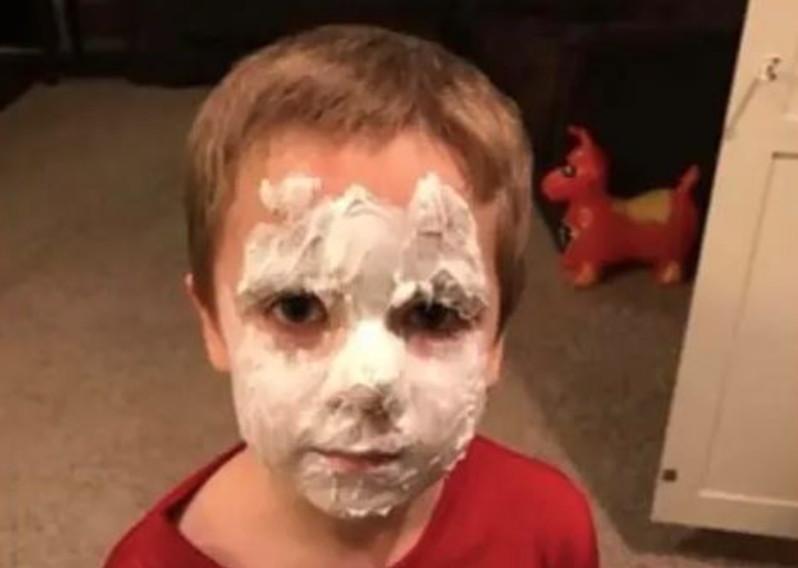 Un enfant qui s'est étalé de la crème sur le visage.