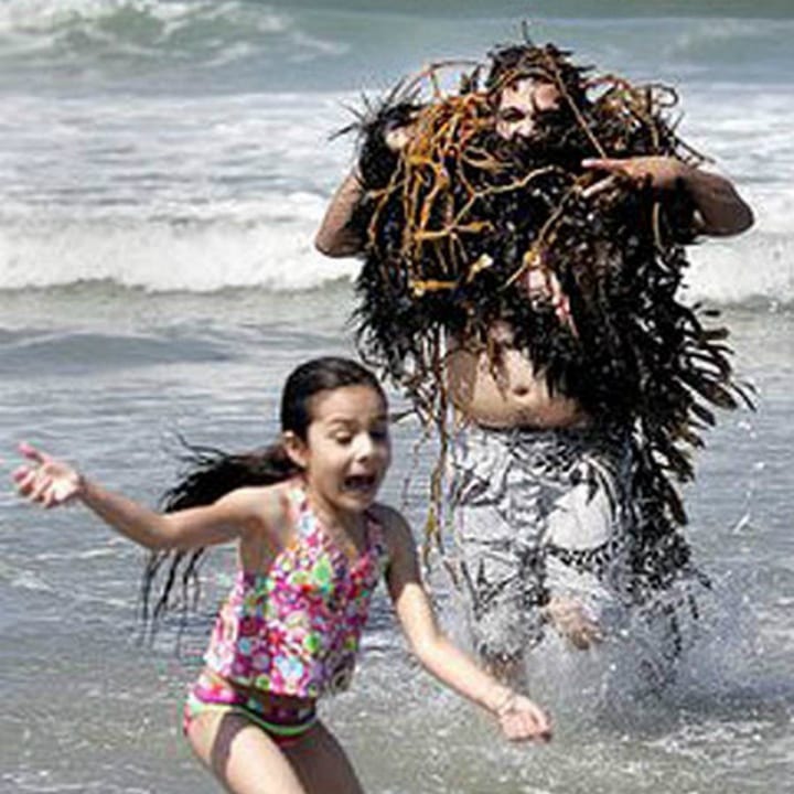 Un nageur déguisé avec des algues de mer