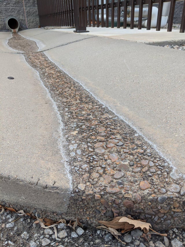 de l'eau qui provoque l'érosion d'une route en ciment