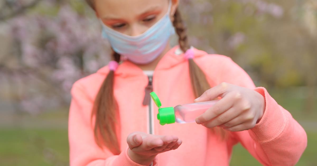 Une fillette se met du gel hydroalcoolique.