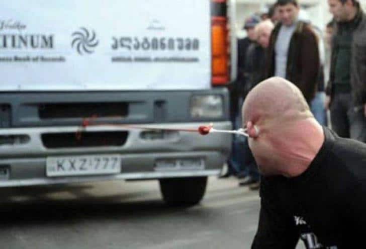 Un homme qui tire un camion avec son oreille