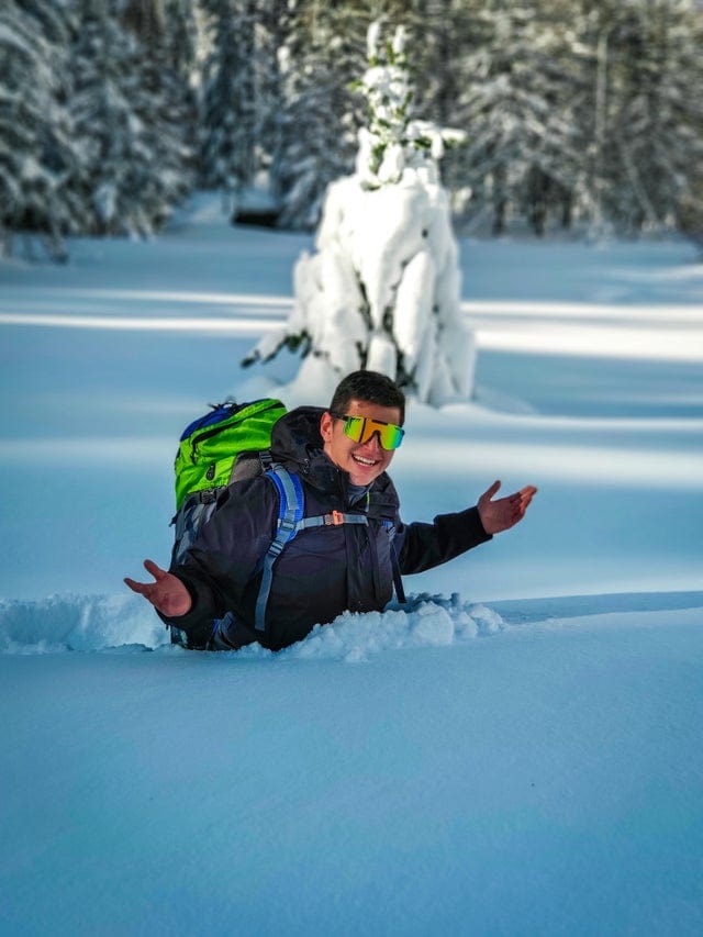 Un homme immergé dans la neige jusqu'au torse