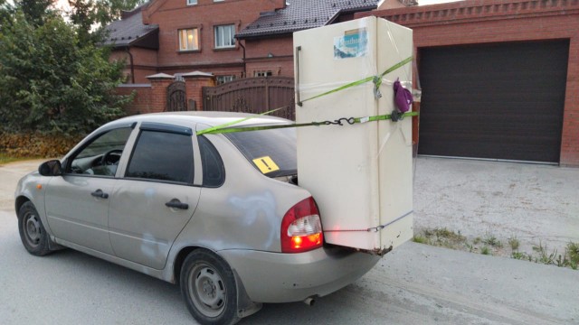 Un réfrigérateur transporté dans le coffre d'une voiture