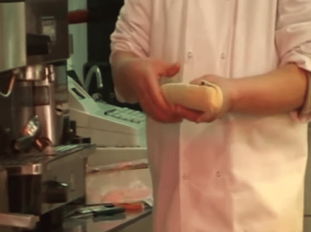 Le boulanger prépare un sandwich sans porter de gants.