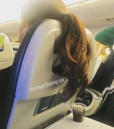 La chevelure d'une passagère dans un avion