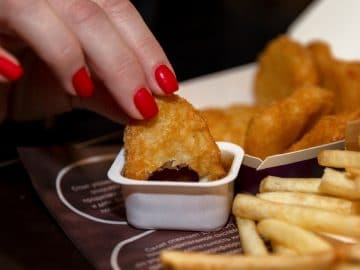 Une femme mange des nuggets McDonald's.