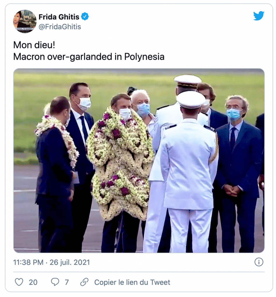 Emmanuel Macron couvert de couronnes de fleurs