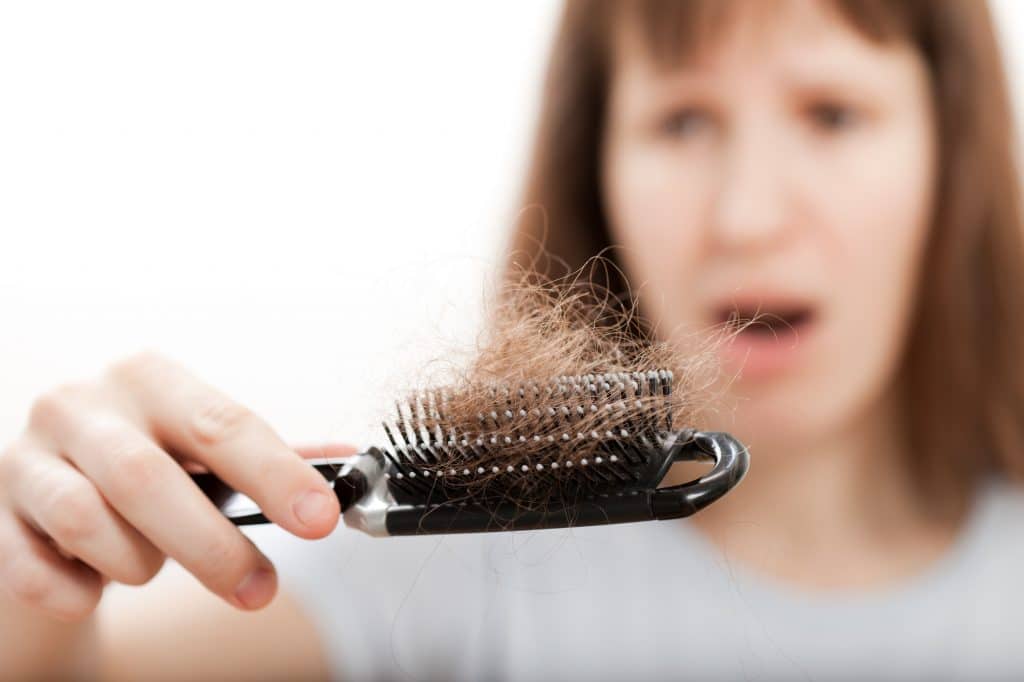 jeune femme perdant ses cheveux après le brossage