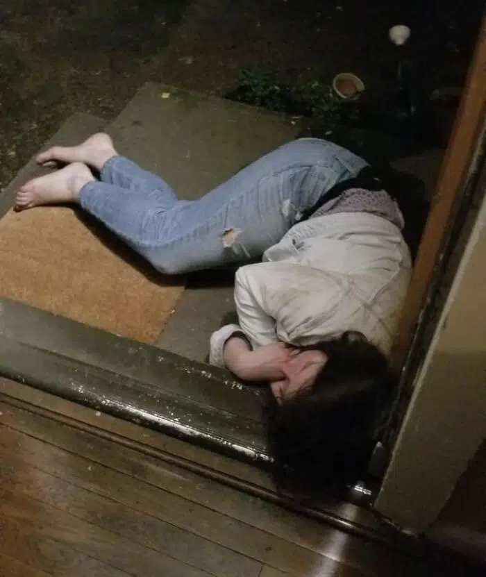 Une femme allongée à l'entrée de la maison